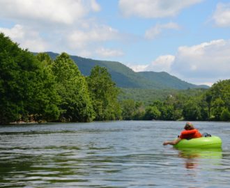 a young person tubing down very calm waters while enjoying the scenery Downriver Canoe Company Shenandoah Valley River